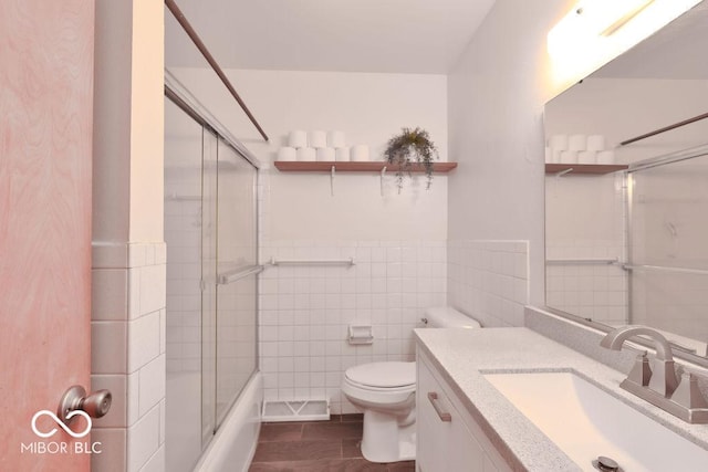 7525 Surrey Dr, Indianapolis, IN 46227 - bathroom with tile walls, vanity, combined bath / shower with glass door, and a wainscoted wall