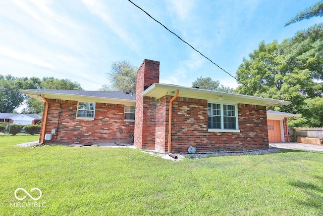 7525 Surrey Dr, Indianapolis, IN 46227 - rear view of house featuring a chimney, a garage, brick siding, and driveway