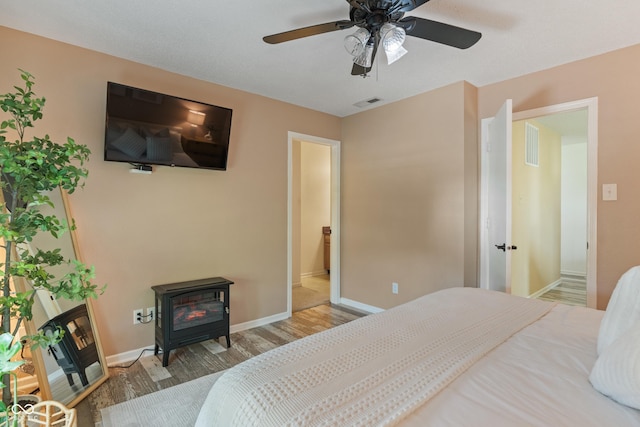 2564 Woodfield Blvd, Franklin, IN 46131 - bedroom with wood finished floors, a wood stove, and a ceiling fan