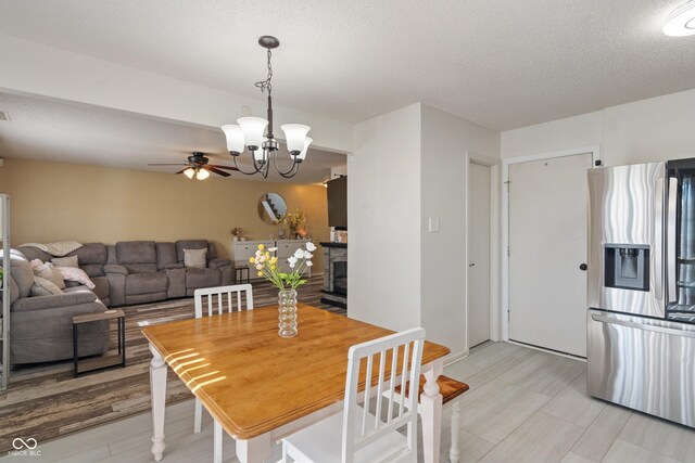 2564 Woodfield Blvd, Franklin, IN 46131 - dining space with a ceiling fan, a chandelier, a textured ceiling, and a fireplace