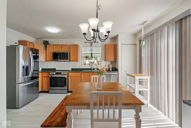 2564 Woodfield Blvd, Franklin, IN 46131 - kitchen with appliances with stainless steel finishes, dark countertops, a chandelier, a textured ceiling, and hanging light fixtures