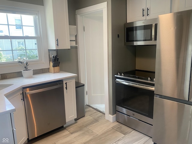 5220 Crawfordsville Rd, Speedway, IN 46224 - kitchen featuring stainless steel appliances, light countertops, white cabinets, and light wood-style flooring