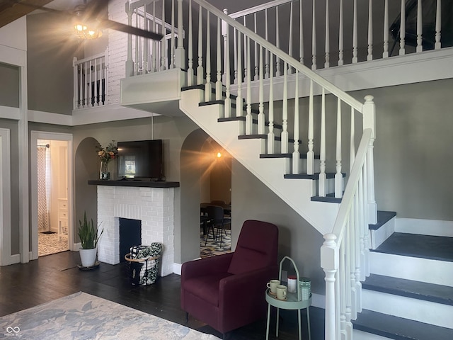 5220 Crawfordsville Rd, Speedway, IN 46224 - stairway featuring a towering ceiling, wood finished floors, and a brick fireplace
