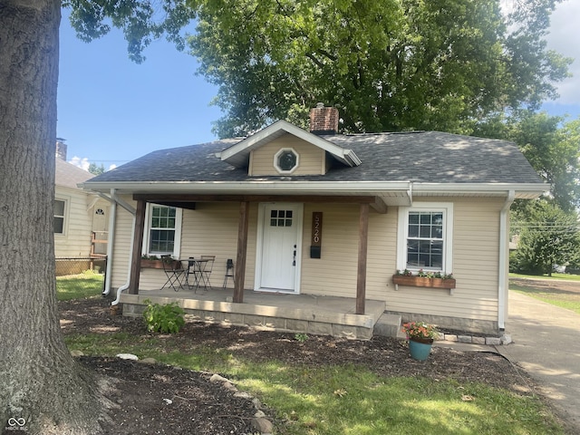 5220 Crawfordsville Rd, Speedway, IN 46224 - bungalow featuring covered porch, a chimney, and a shingled roof