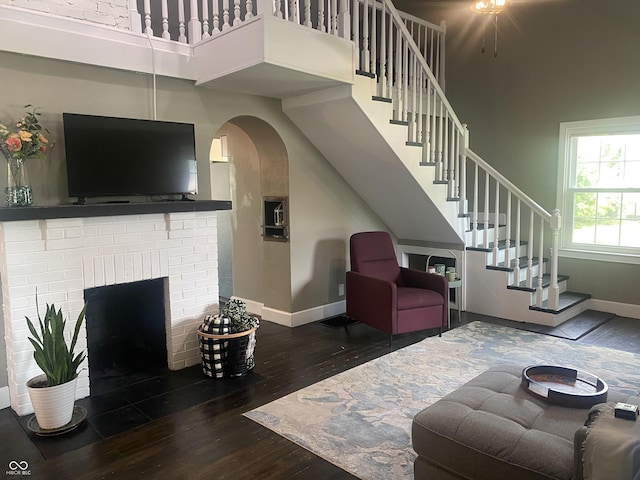 5220 Crawfordsville Rd, Speedway, IN 46224 - living area with wood finished floors, a high ceiling, stairway, a fireplace, and arched walkways