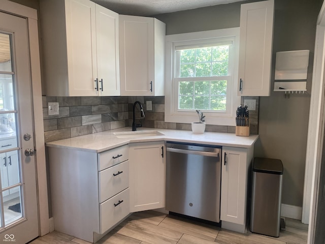 5220 Crawfordsville Rd, Speedway, IN 46224 - kitchen with dishwasher, light countertops, decorative backsplash, and white cabinetry