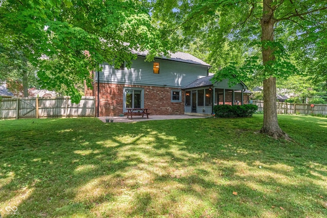 12011 Emory Dr, Indianapolis, IN 46229 - back of house featuring a sunroom, brick siding, a fenced backyard, and a patio