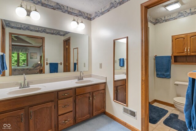 12011 Emory Dr, Indianapolis, IN 46229 - bathroom featuring a textured ceiling, double vanity, and ensuite bathroom
