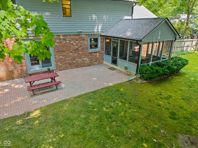 12011 Emory Dr, Indianapolis, IN 46229 - rear view of house with a sunroom, brick siding, a patio area, and a shingled roof