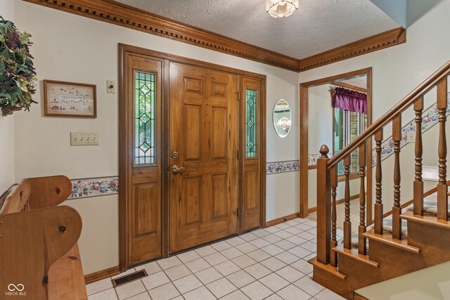 12011 Emory Dr, Indianapolis, IN 46229 - foyer entrance featuring a textured ceiling, stairs, light tile patterned flooring, and ornamental molding