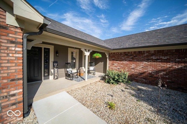 2259 Willow Lake Dr, Greenwood, IN 46143 - view of exterior entry with brick siding, a porch, and roof with shingles