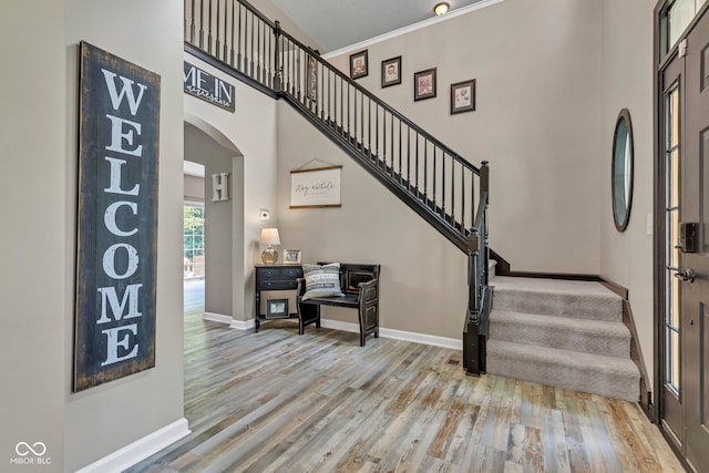 5961 Pine Bluff Dr, Avon, IN 46123 - entrance foyer featuring stairway, arched walkways, wood finished floors, and crown molding