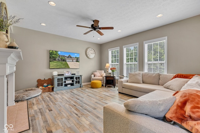 5961 Pine Bluff Dr, Avon, IN 46123 - living area with light wood finished floors, a ceiling fan, recessed lighting, a textured ceiling, and a fireplace