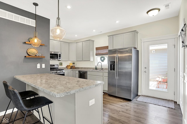 3588 Thomas Jefferson St, Westfield, IN 46074 - kitchen featuring appliances with stainless steel finishes, open shelves, light countertops, a breakfast bar area, and light wood finished floors