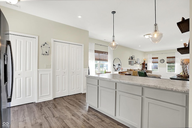 3588 Thomas Jefferson St, Westfield, IN 46074 - kitchen with light countertops, hanging light fixtures, stainless steel fridge, wood finished floors, and open floor plan