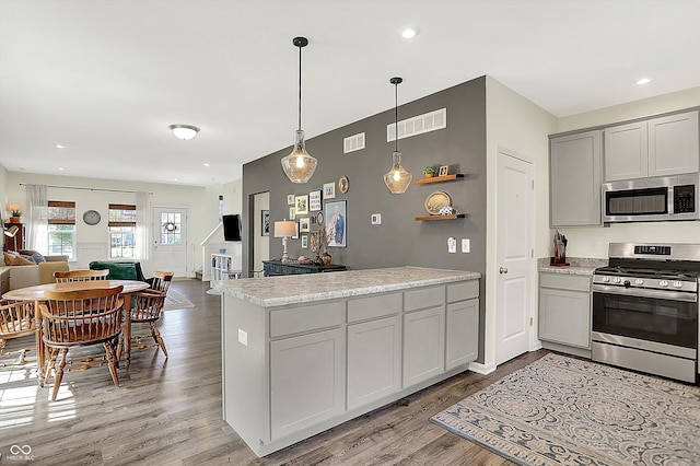 3588 Thomas Jefferson St, Westfield, IN 46074 - kitchen with appliances with stainless steel finishes, open floor plan, a peninsula, gray cabinets, and light wood-type flooring