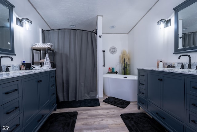 2501 Mitten Rd, Bowling Green, IN 47833 - full bath featuring two vanities, a freestanding tub, a shower with shower curtain, and wood finished floors