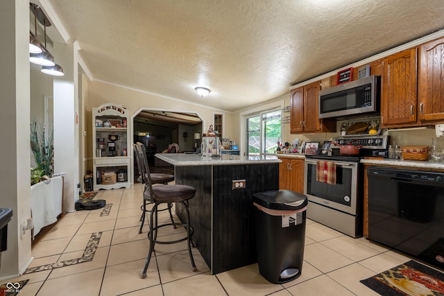 2501 Mitten Rd, Bowling Green, IN 47833 - kitchen with stainless steel appliances, light tile patterned floors, a kitchen island, a textured ceiling, and a breakfast bar