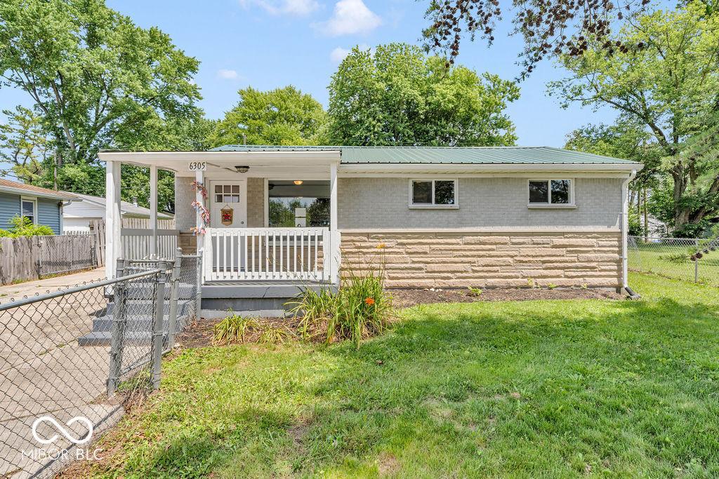 6305 Vigo Dr, Clayton, IN 46118 - ranch-style house with stone siding, a porch, and a metal roof