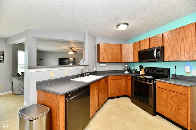 2016 Morning Light Ln, Greenwood, IN 46143 - kitchen featuring stainless steel appliances, dark countertops, brown cabinets, ceiling fan, and a textured ceiling