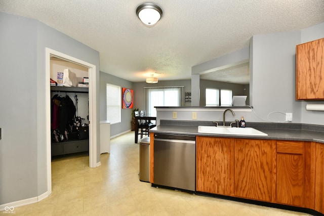 2016 Morning Light Ln, Greenwood, IN 46143 - kitchen featuring dishwasher, a textured ceiling, brown cabinetry, dark countertops, and a peninsula