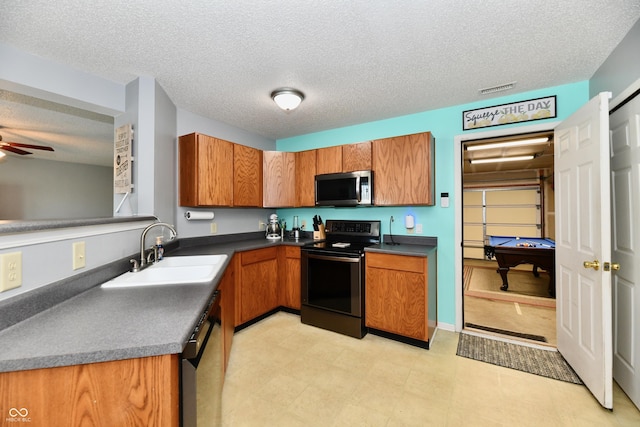 2016 Morning Light Ln, Greenwood, IN 46143 - kitchen featuring appliances with stainless steel finishes, brown cabinets, dark countertops, a textured ceiling, and ceiling fan