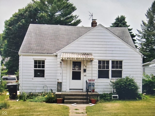518 E Irvington Ave, South Bend, IN 46614 - bungalow featuring a chimney, a front lawn, and roof with shingles
