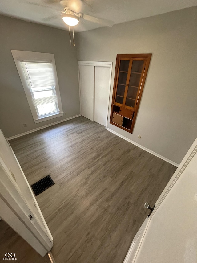 849 S Belleview Pl, Indianapolis, IN 46221 - unfurnished bedroom featuring wood finished floors, a closet, and ceiling fan