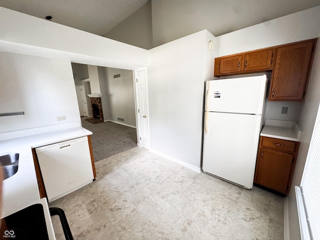9672 River Oak Ln E, Fishers, IN 46038 - kitchen with white appliances, brown cabinets, light countertops, high vaulted ceiling, and a brick fireplace