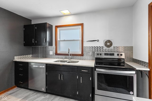 320 S Odell St, Brownsburg, IN 46112 - kitchen with dark cabinets, appliances with stainless steel finishes, light countertops, light wood-style floors, and decorative backsplash
