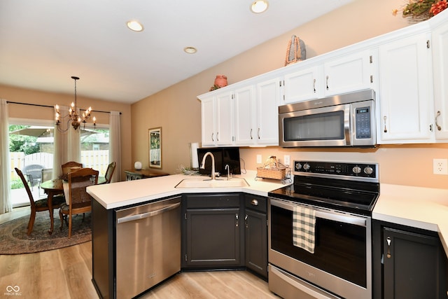 1603 Oakmere Way, Greenwood, IN 46142 - kitchen featuring stainless steel appliances, white cabinets, light wood-style flooring, a peninsula, and recessed lighting