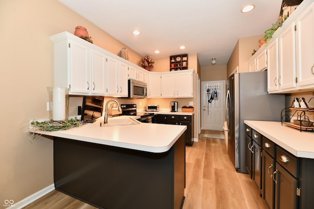 1603 Oakmere Way, Greenwood, IN 46142 - kitchen featuring a peninsula, white cabinets, light countertops, light wood-type flooring, and appliances with stainless steel finishes