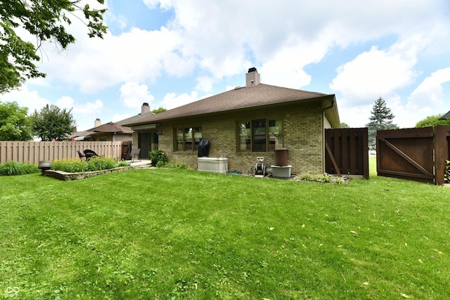 1603 Oakmere Way, Greenwood, IN 46142 - back of property with brick siding, a chimney, and a gate
