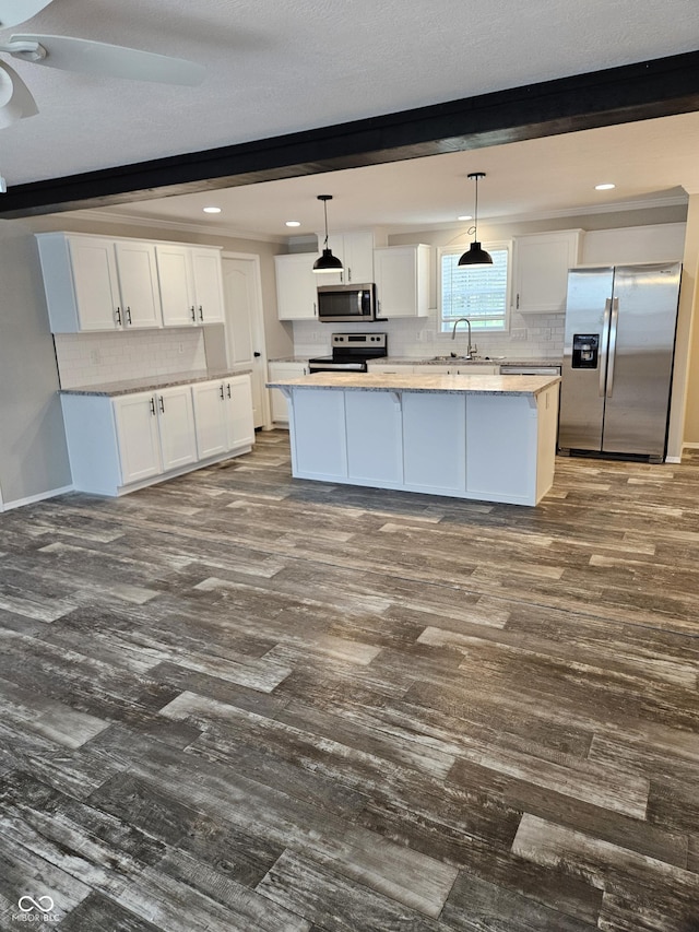 3920 Brandywyne Dr, North Vernon, IN 47265 - kitchen with stainless steel appliances, white cabinetry, a center island, decorative backsplash, and dark wood-style flooring