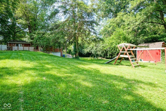 4720 Kessler View Dr, Indianapolis, IN 46220 - view of grassy yard featuring a playground, a shed, and view of scattered trees