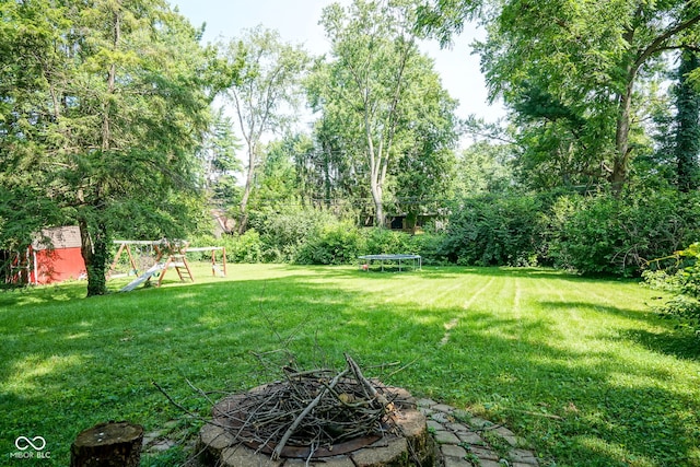 4720 Kessler View Dr, Indianapolis, IN 46220 - view of green lawn featuring a fire pit, a playground, and a storage shed