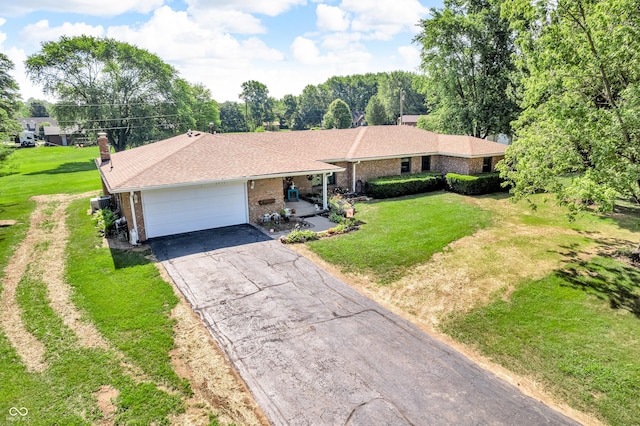 2571 Stonybrook Ln, Franklin, IN 46131 - single story home with brick siding, a garage, driveway, a chimney, and a front lawn