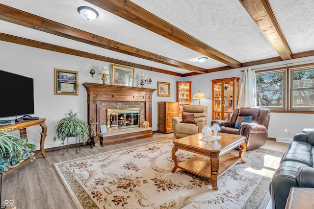 2571 Stonybrook Ln, Franklin, IN 46131 - living area featuring a textured ceiling, light wood-type flooring, beamed ceiling, and a fireplace