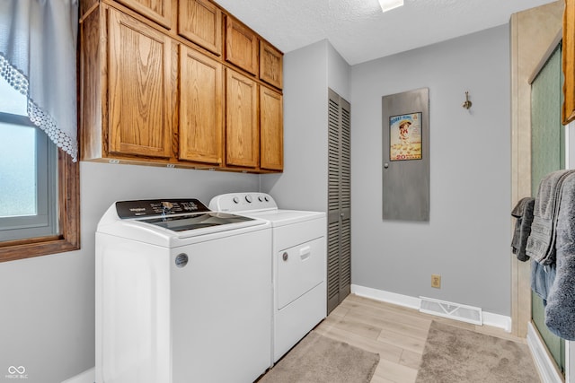 2571 Stonybrook Ln, Franklin, IN 46131 - washroom featuring cabinet space, washing machine and dryer, light wood-style floors, and a textured ceiling