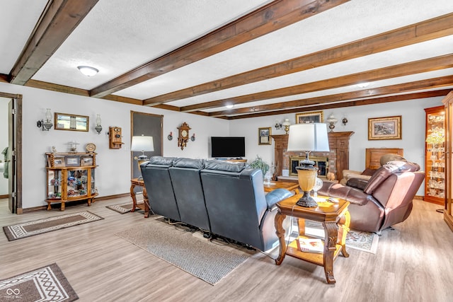 2571 Stonybrook Ln, Franklin, IN 46131 - living room featuring light wood-style floors, beam ceiling, a brick fireplace, and a textured ceiling