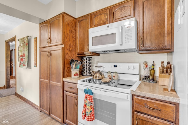 2571 Stonybrook Ln, Franklin, IN 46131 - kitchen featuring white appliances, decorative backsplash, brown cabinetry, and light wood-type flooring