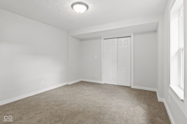 135 S Dr, Anderson, IN 46013 - unfurnished bedroom featuring carpet flooring, a textured ceiling, and a closet