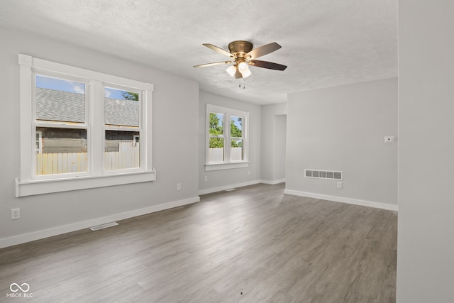 135 S Dr, Anderson, IN 46013 - unfurnished living room with a textured ceiling, a ceiling fan, and wood finished floors