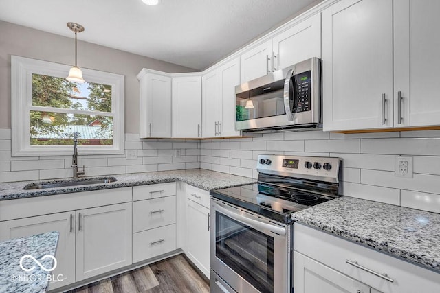 354 Mill Spgs, Fillmore, IN 46128 - kitchen with appliances with stainless steel finishes, white cabinetry, tasteful backsplash, dark wood-type flooring, and pendant lighting
