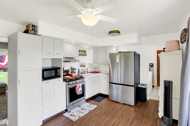 2630 Flintwood Dr, Columbus, IN 47203 - kitchen with appliances with stainless steel finishes, under cabinet range hood, dark wood-type flooring, and white cabinetry