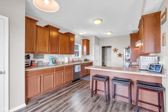 1397 Greenbriar Way, Franklin, IN 46131 - kitchen featuring appliances with stainless steel finishes, brown cabinetry, wood finished floors, a peninsula, and a kitchen breakfast bar