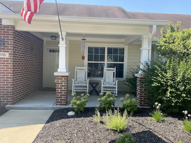 1675 Leisure Way, Greenfield, IN 46140 - property entrance with a porch, brick siding, and a shingled roof