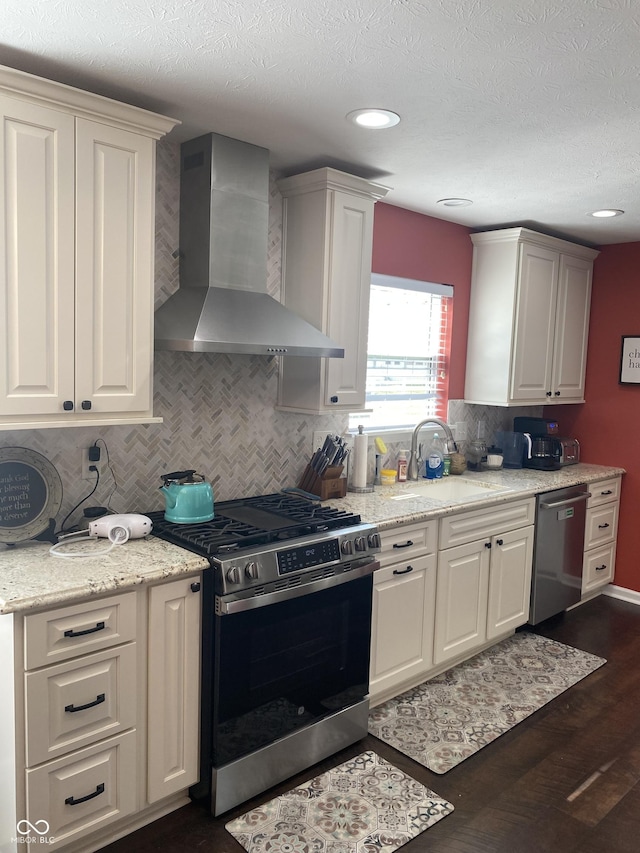 1675 Leisure Way, Greenfield, IN 46140 - kitchen featuring wall chimney range hood, stainless steel appliances, backsplash, dark wood-style floors, and white cabinets