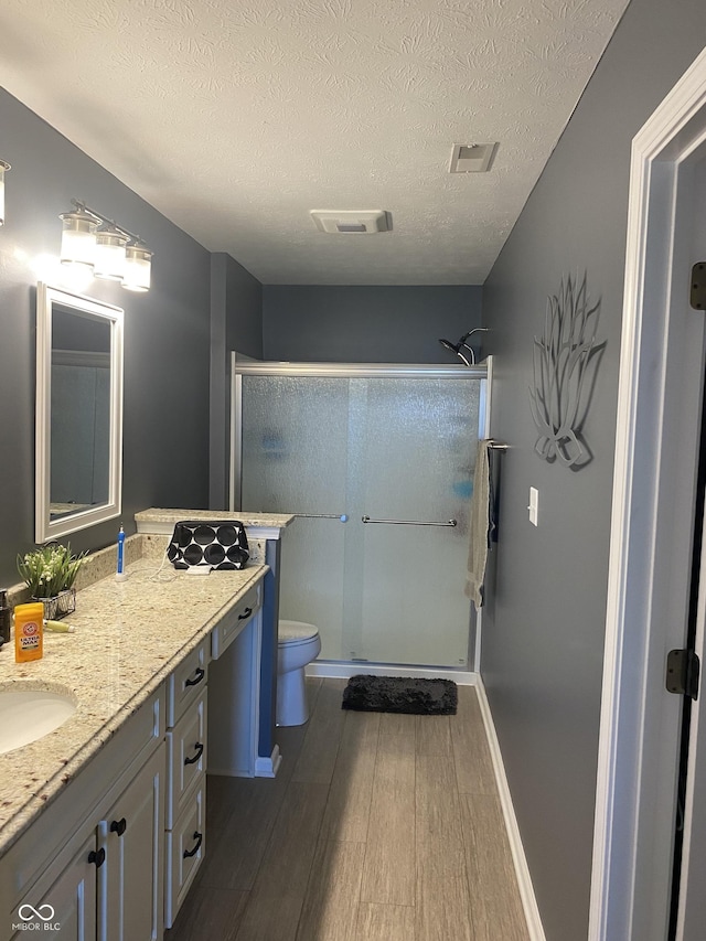 1675 Leisure Way, Greenfield, IN 46140 - full bath with a stall shower, wood finished floors, vanity, and a textured ceiling