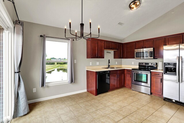 13225 Deception Pass Unit 700, Fishers, IN 46038 - kitchen with appliances with stainless steel finishes, a chandelier, light countertops, lofted ceiling, and reddish brown cabinets
